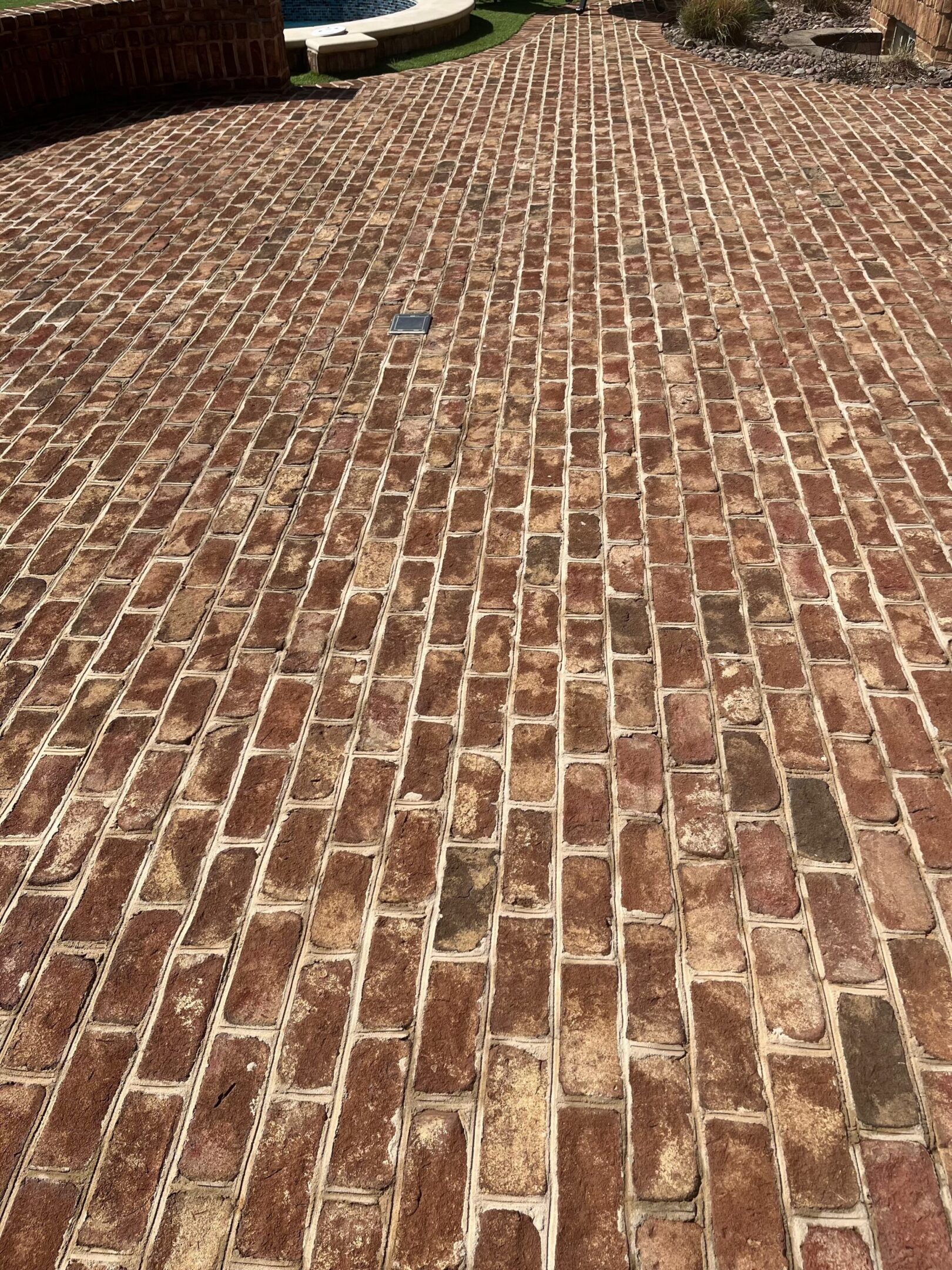 Close-up of a red brick pavement arranged in a staggered pattern.
