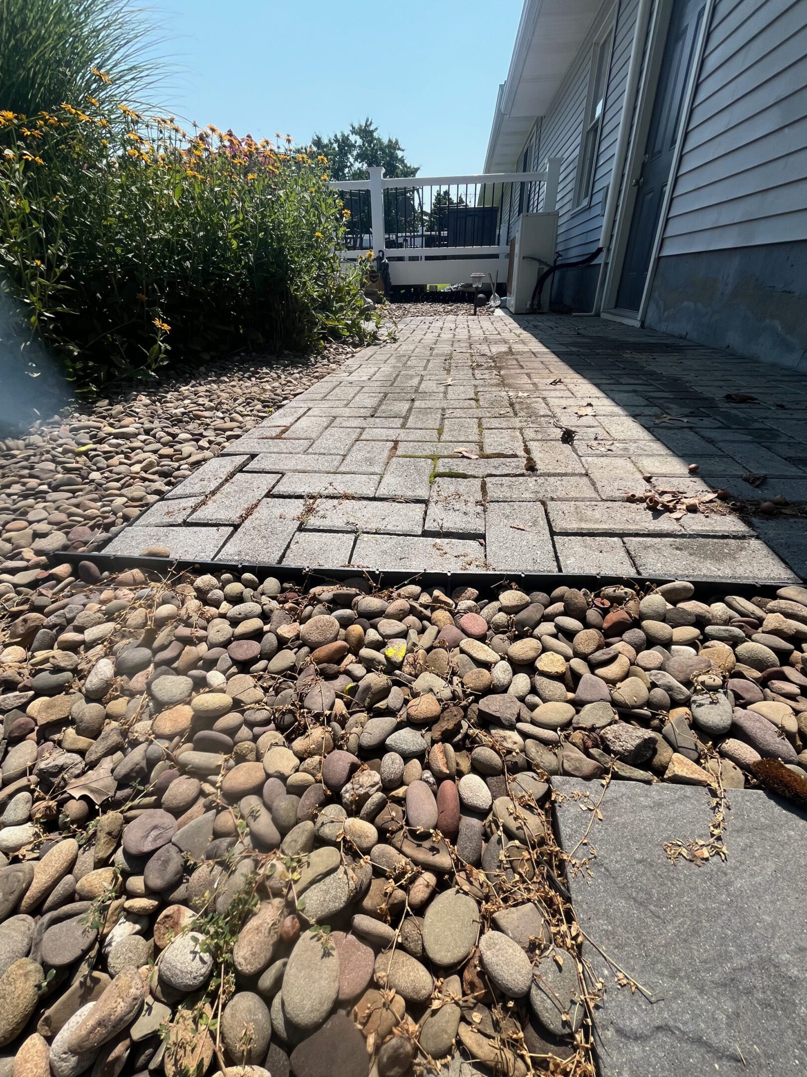 A stone pathway laid over pebbles between buildings.