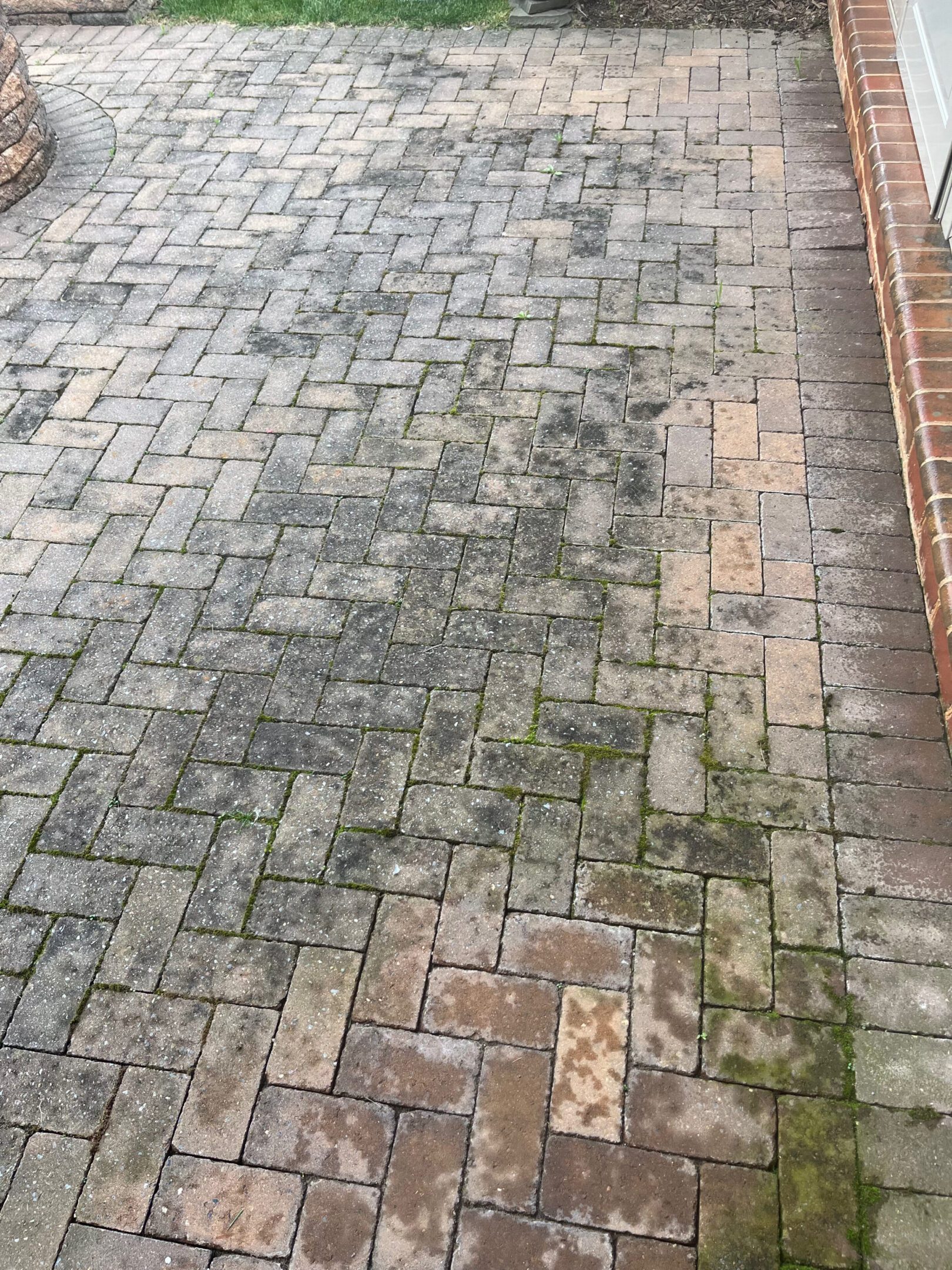 Weathered herringbone brick patio with moss