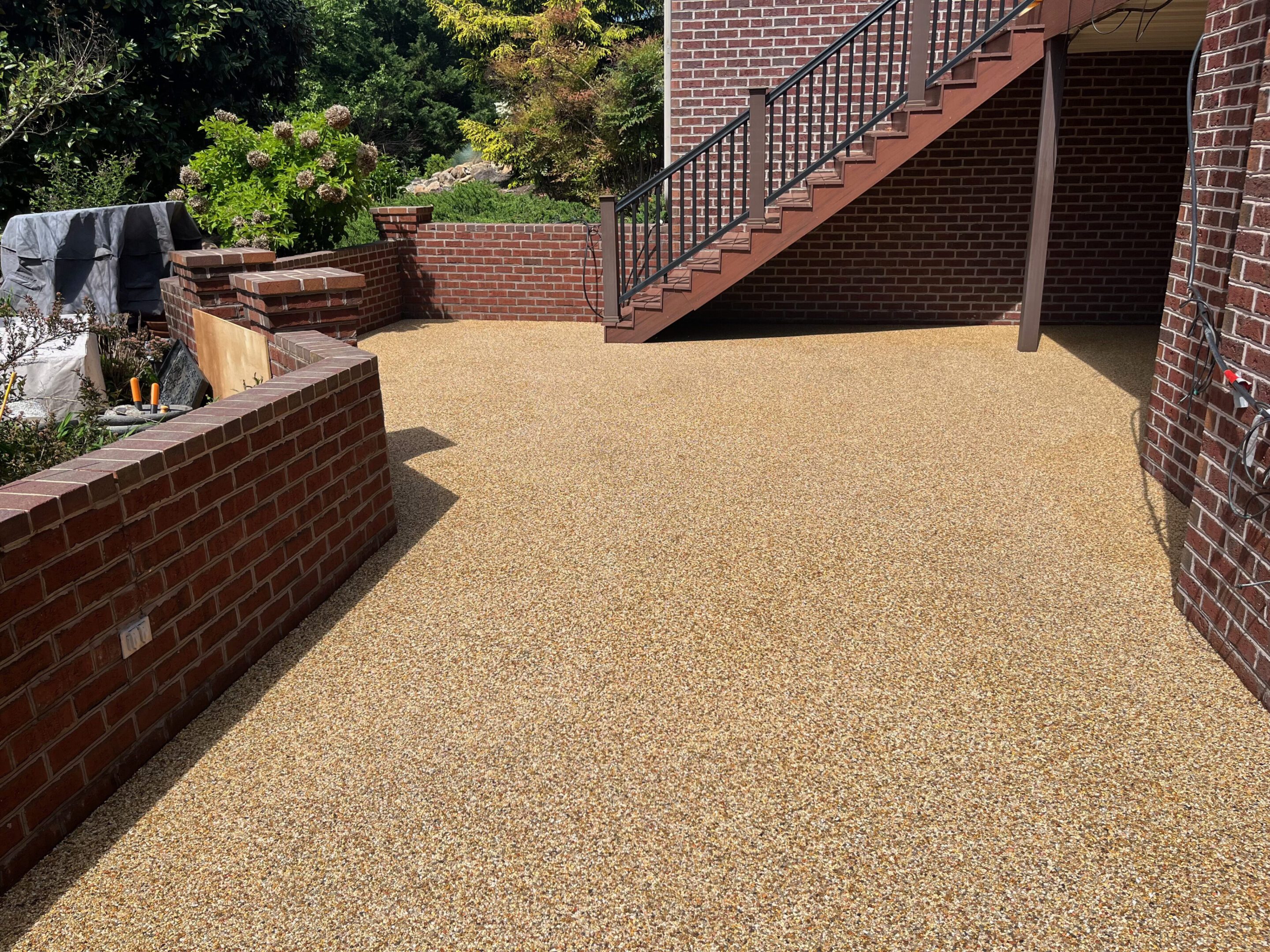 A clean outdoor patio area with gravel flooring and brick walls.