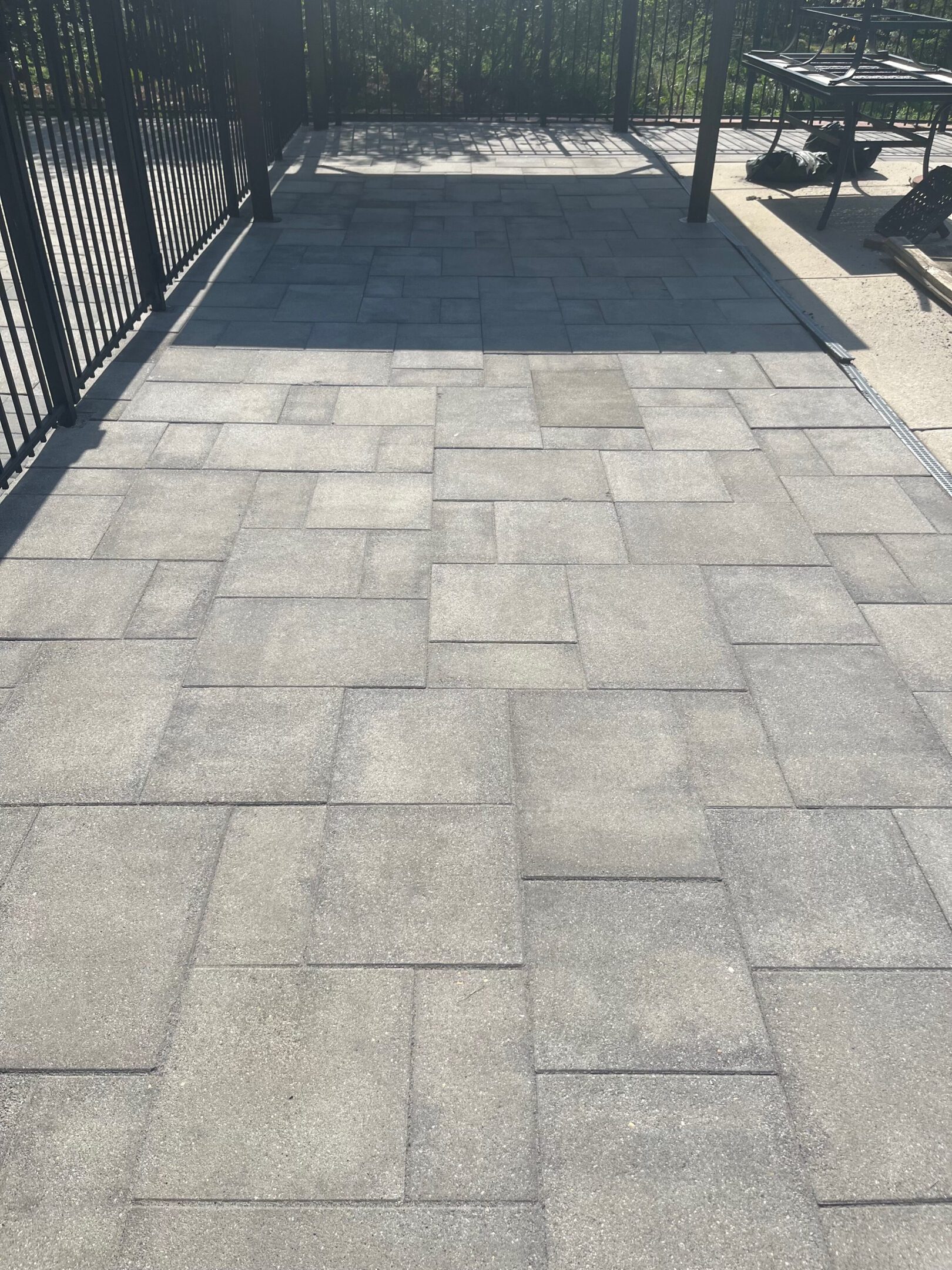 A paved walkway with gray rectangular stones in a staggered pattern.