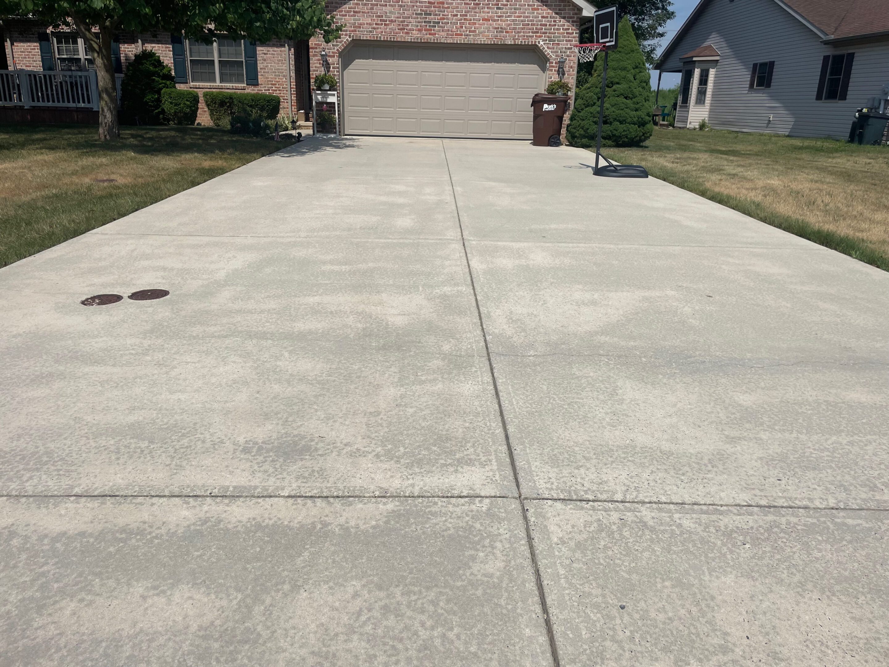 A wide, clean concrete driveway leading to a closed garage door.
